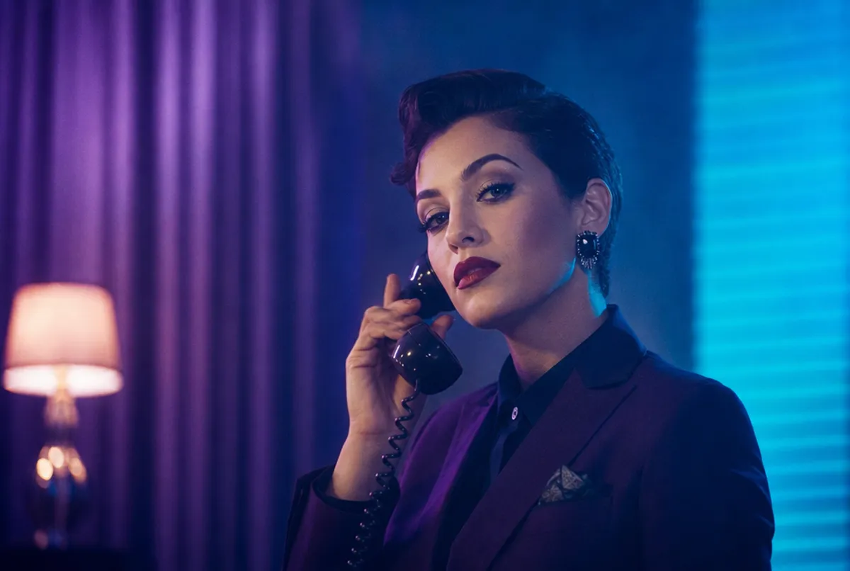 Glamour&ouml;se Person mit elegantem Make-up am Telefon, Violett-Cyan-Licht